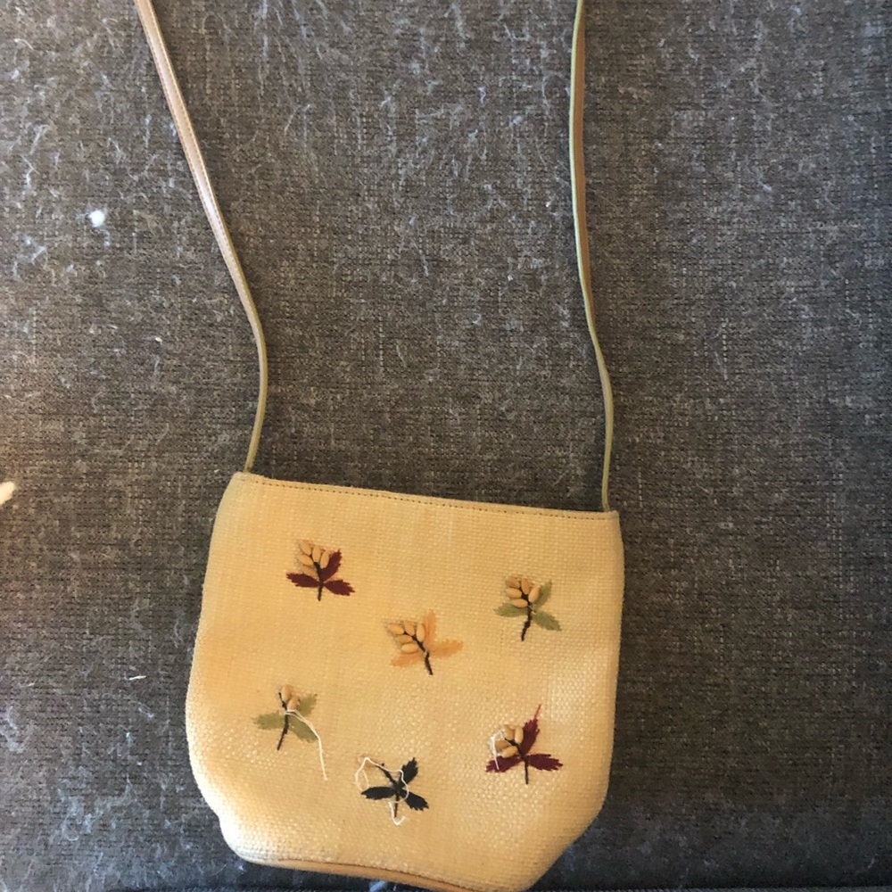 beige/yellowish purse with colorful flowers on it. embroided soft material
